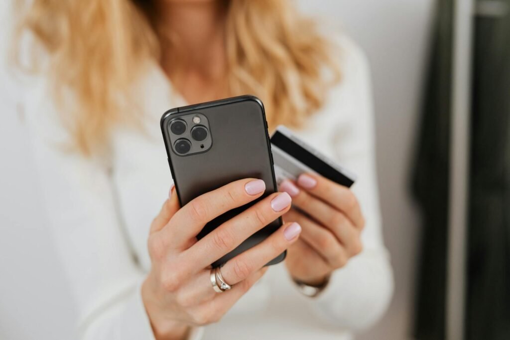 Close-Up Shot of a Person Holding a Credit Card and a Smartphone