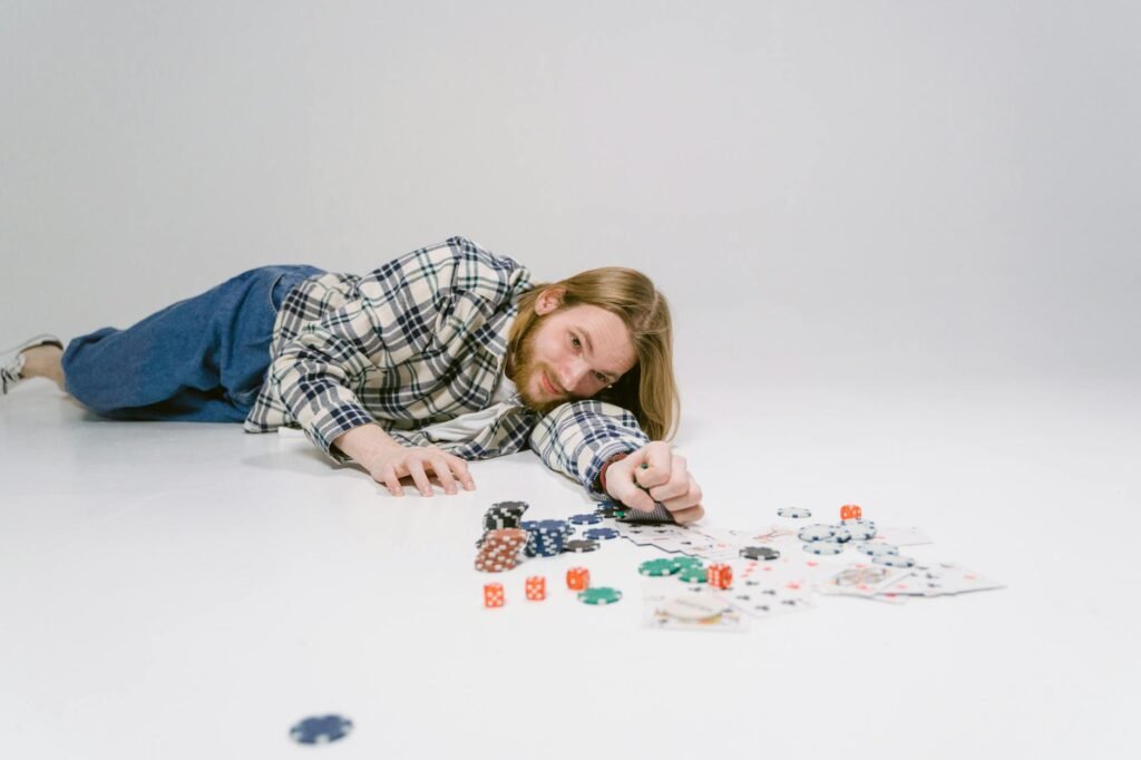 Girl in Blue and White Plaid Dress Shirt Lying on Floor Playing With Playing Cards
