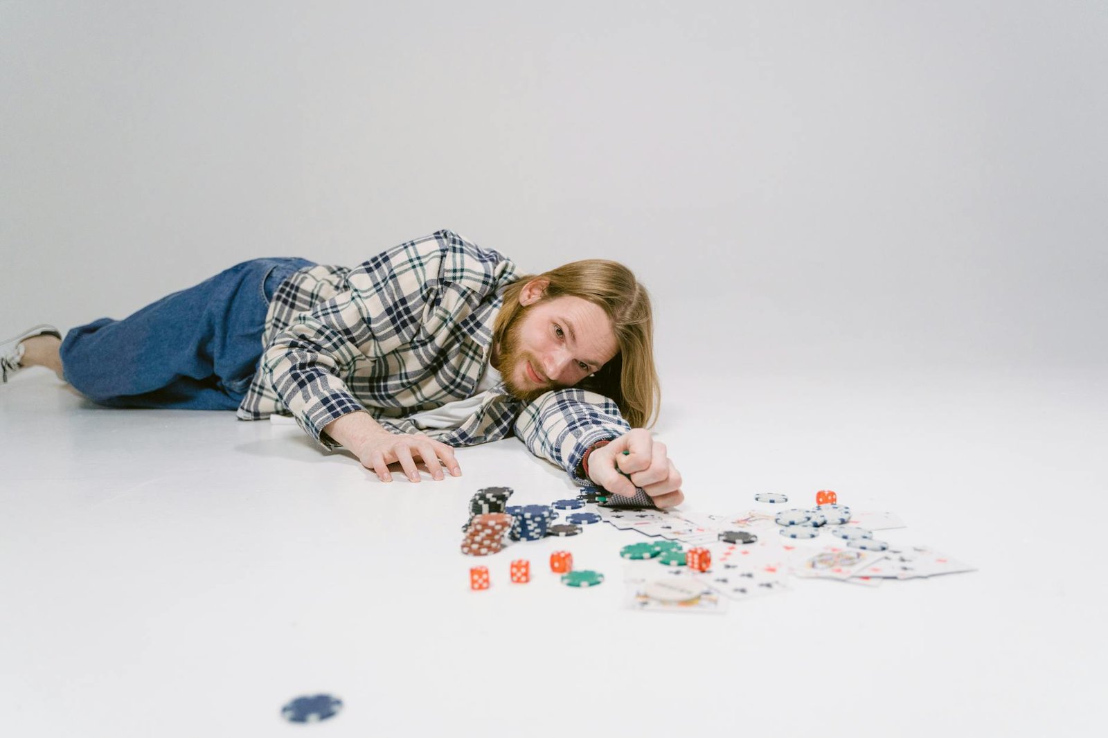 Girl in Blue and White Plaid Dress Shirt Lying on Floor Playing With Playing Cards