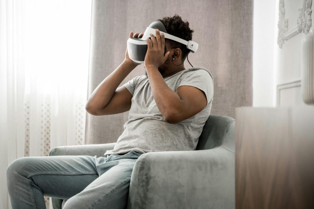 Man in Gray Crew Neck T-shirt Wearing White and Black Vr Goggles