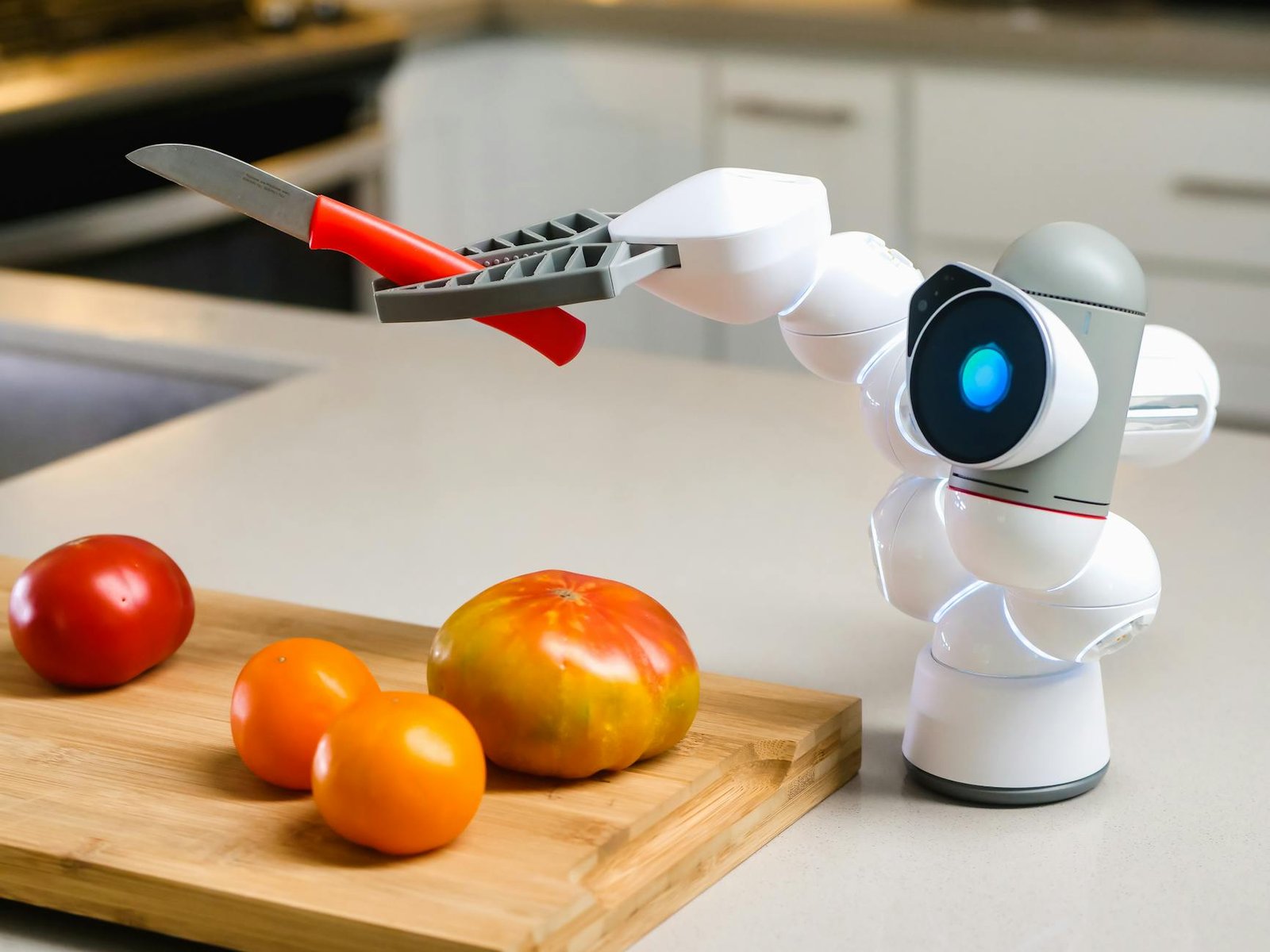image A Clicbot Holding a Knife Beside a Wooden Chopping Board with Tomatoes