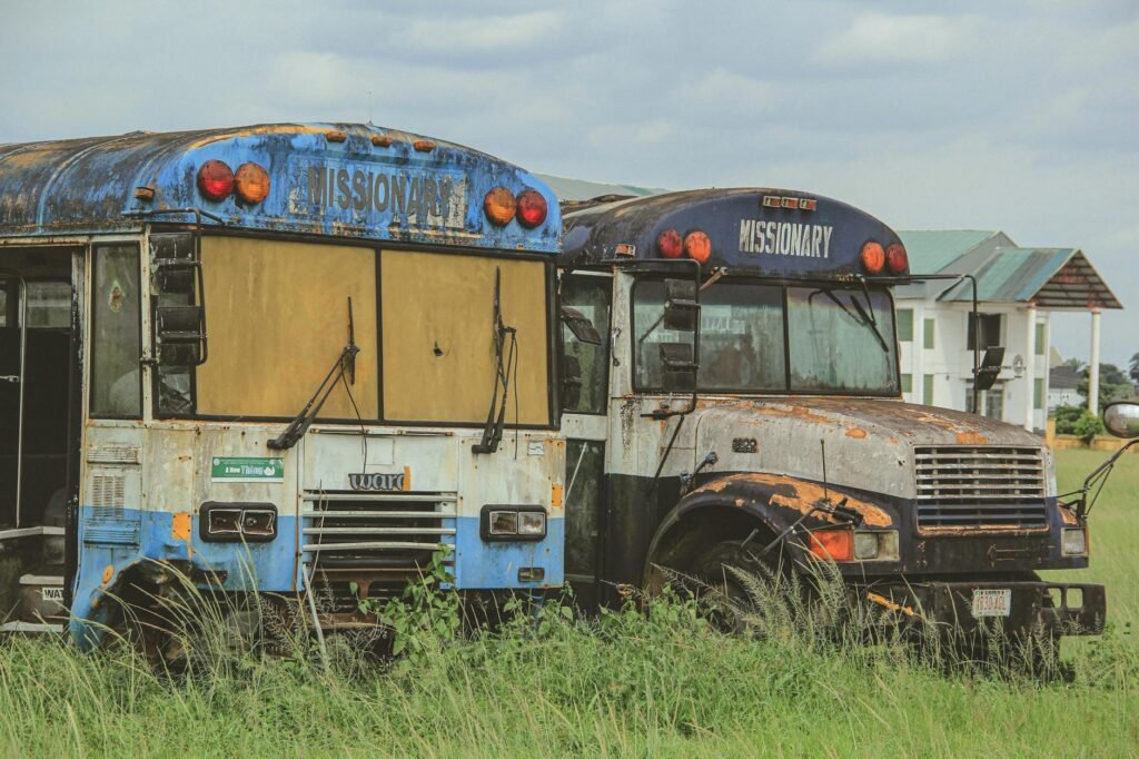 Abandoned, Rusty Buses Parked on a Field