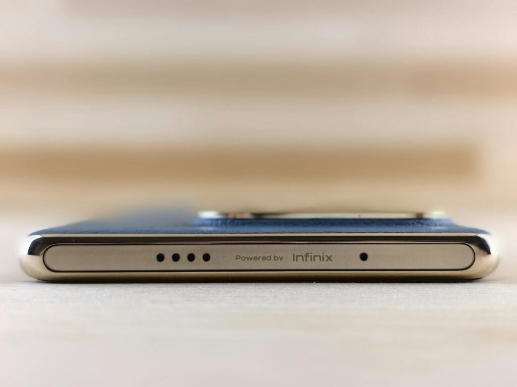 Close-up view of the sleek edge of a smartphone featuring Infinix branding and design.