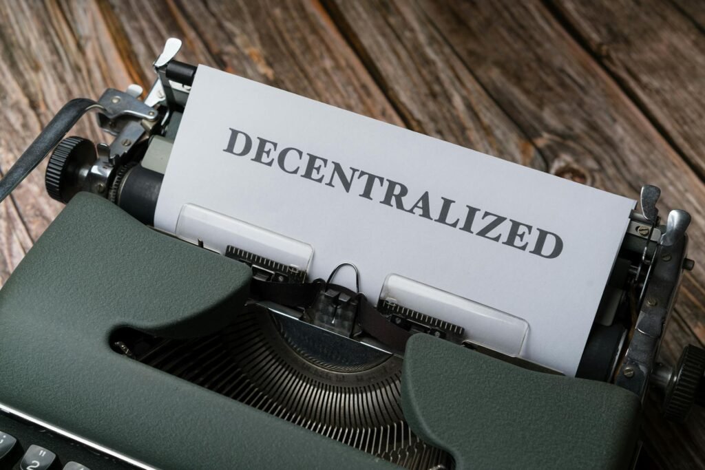 Close-up of a vintage typewriter printing 'DECENTRALIZED' on paper over wooden surface.