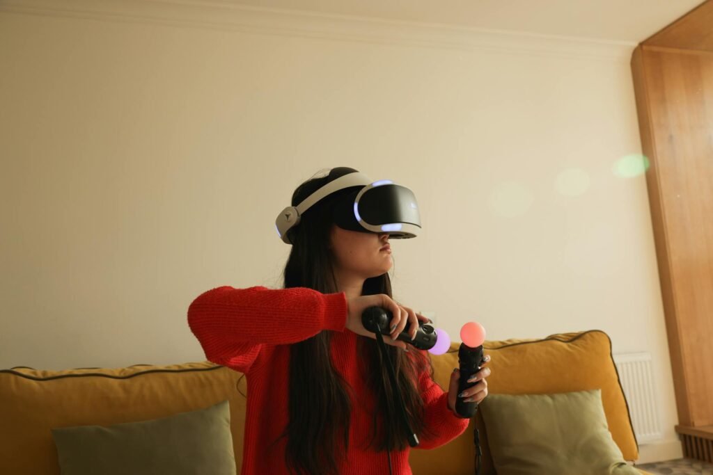 Woman playing VR game with headset and controllers in a cozy indoor setting.