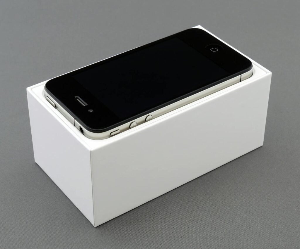 High-quality image of a smartphone placed on a white box, showcasing unboxing.