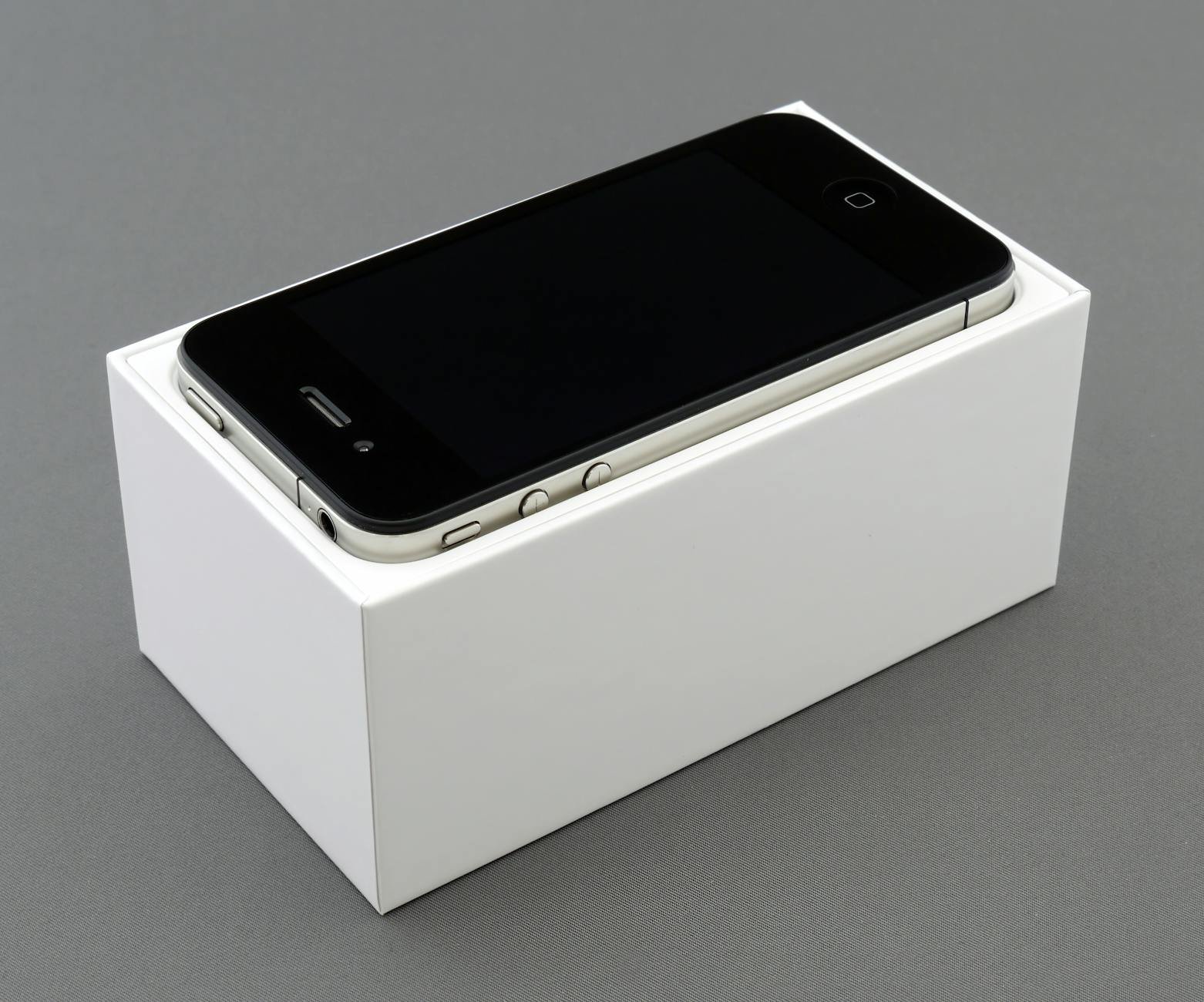 image High-quality image of a smartphone placed on a white box, showcasing unboxing.