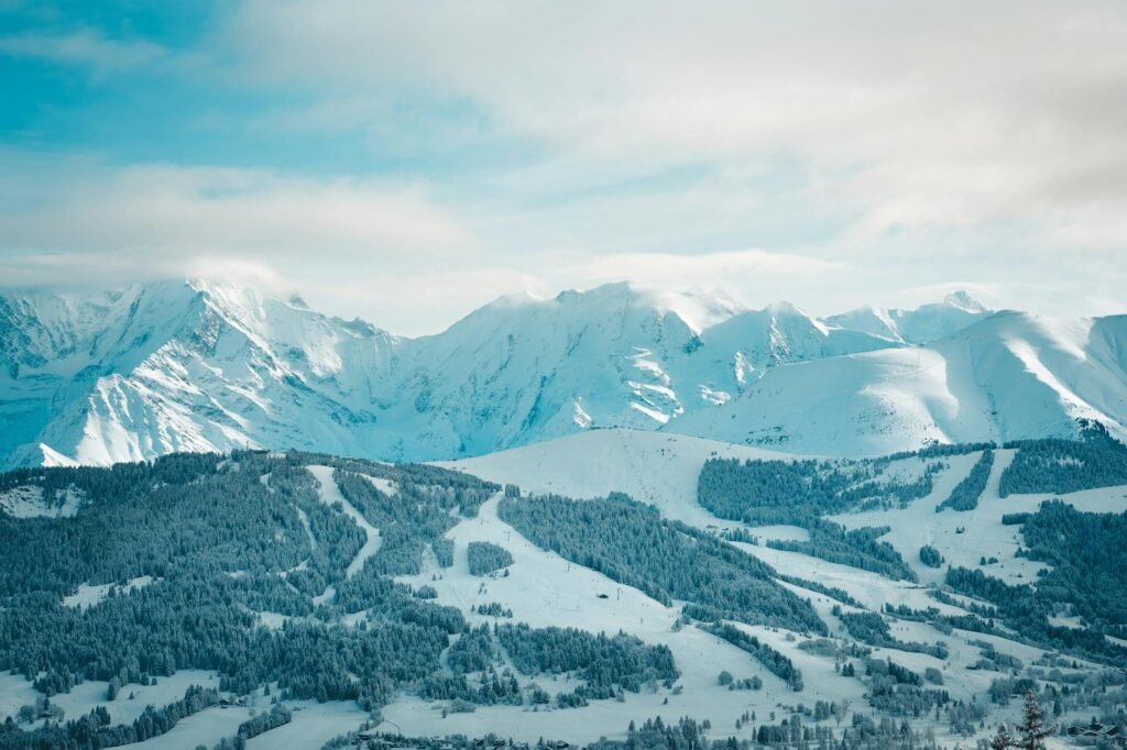 A serene winter landscape showcasing snow-covered mountains and forests in Megève, France.