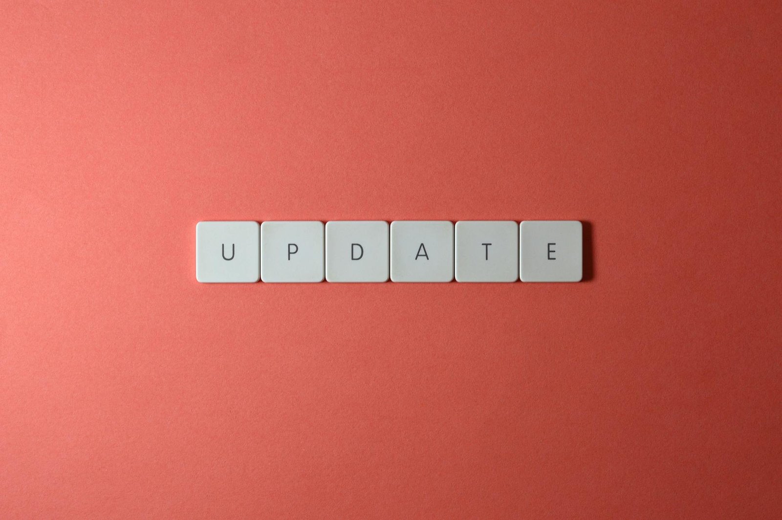 Keyboard keys arranged to spell 'update' on a vibrant red background, ideal for conveying tech concepts.